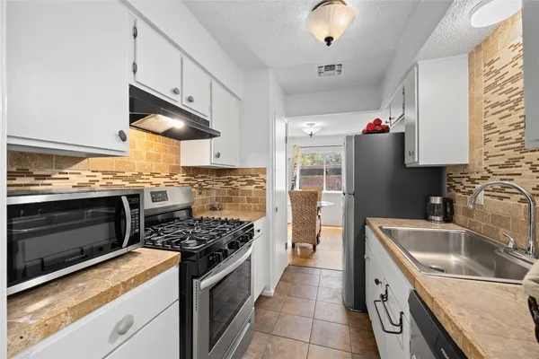 a kitchen with stainless steel appliances granite countertop a stove and a sink
