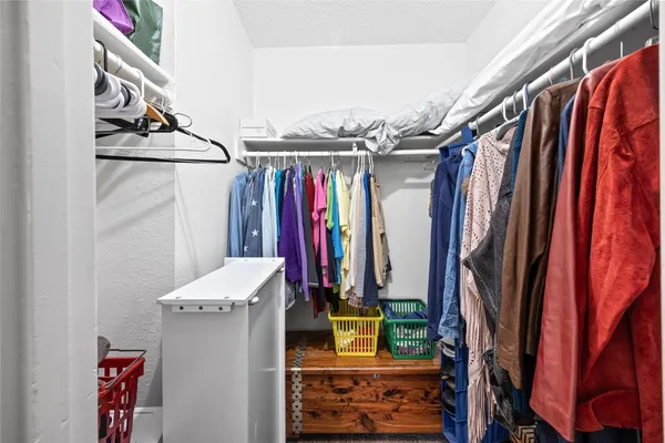 a view of walk in closet with clothes