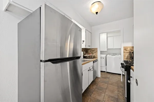 a kitchen with cabinets a refrigerator and a sink