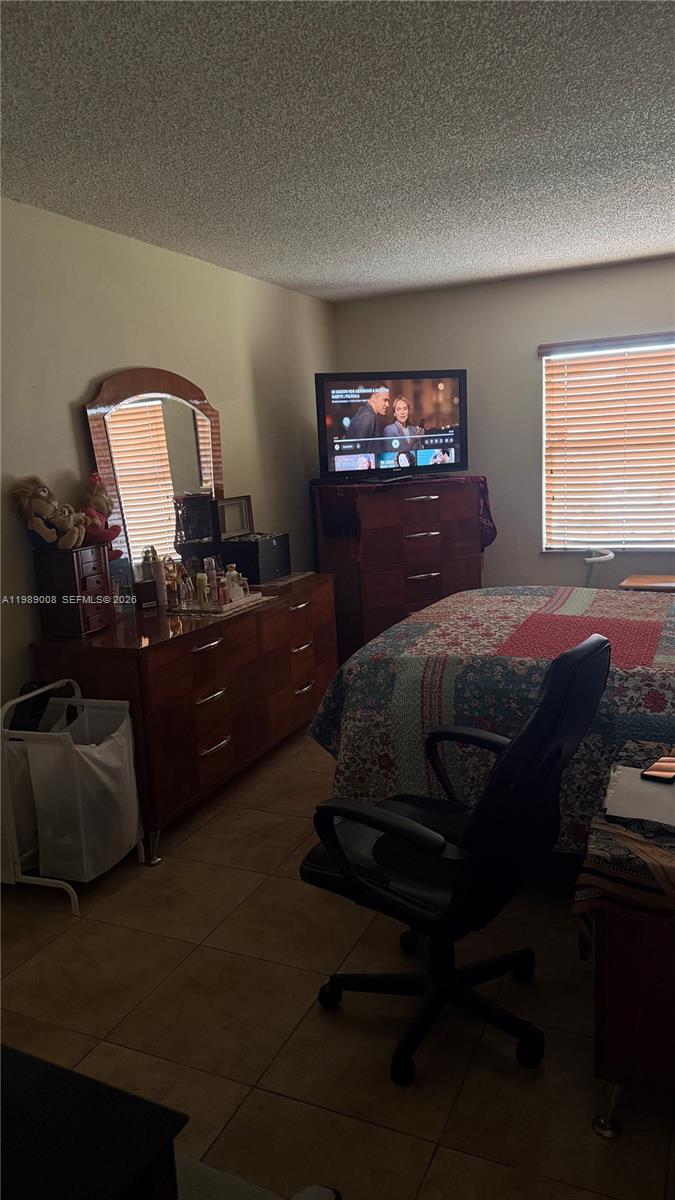 11207 Southwest 88th Street, Unit 216A Miami, FL 33176 - Photo 7 of 9 a bedroom with a bed and a dresser