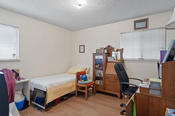 a bedroom with a bed and wooden floor