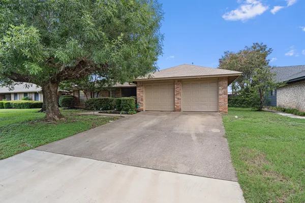 a front view of house with yard and trees