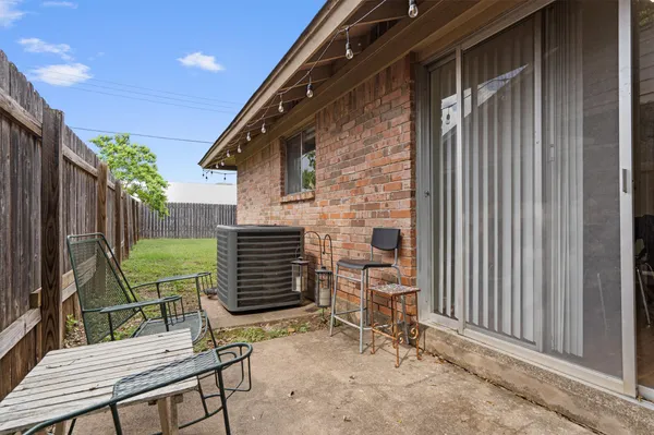 a backyard of a house with barbeque oven table and chairs