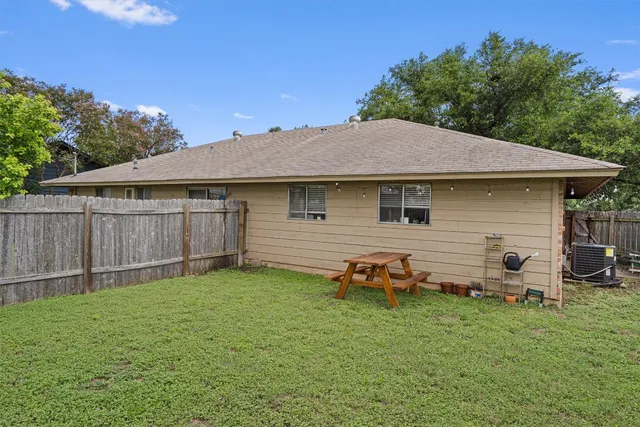 a backyard of a house with table and chairs