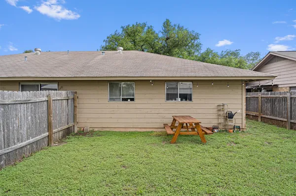 a backyard of a house with table and chairs