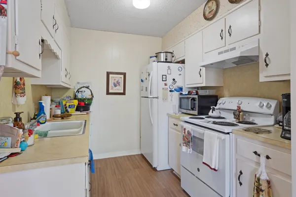 a kitchen with a refrigerator a stove top oven a sink and dishwasher