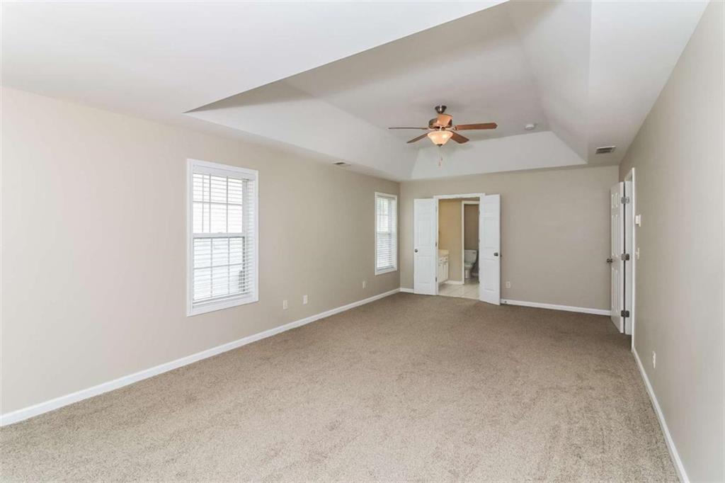 445 Fitzgerald Place Atlanta, GA 30349 - Photo 12 of 15 an empty room with windows and chandelier fan