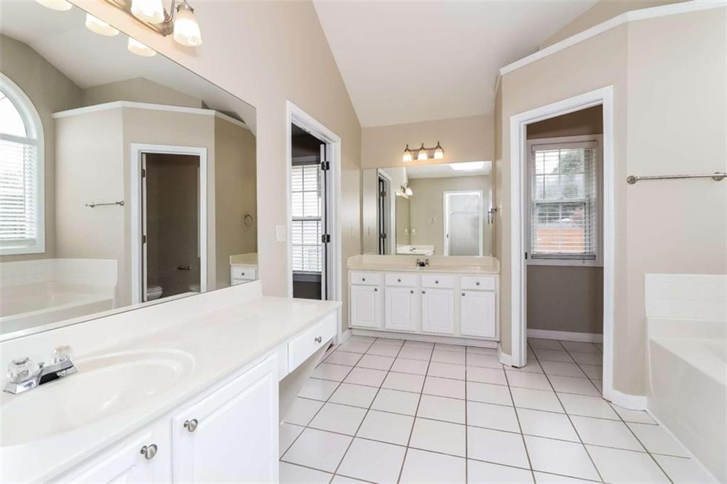 445 Fitzgerald Place Atlanta, GA 30349 - Photo 13 of 15 a large white bathroom with a double vanity sink a mirror and a shower