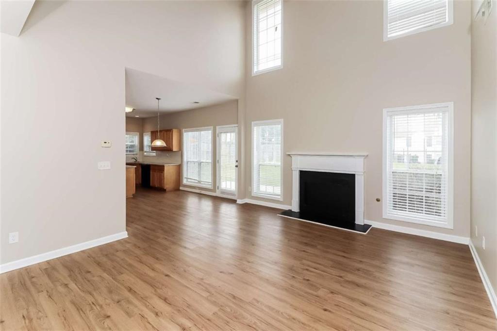445 Fitzgerald Place Atlanta, GA 30349 - Photo 10 of 15 an empty room with wooden floor and fireplace