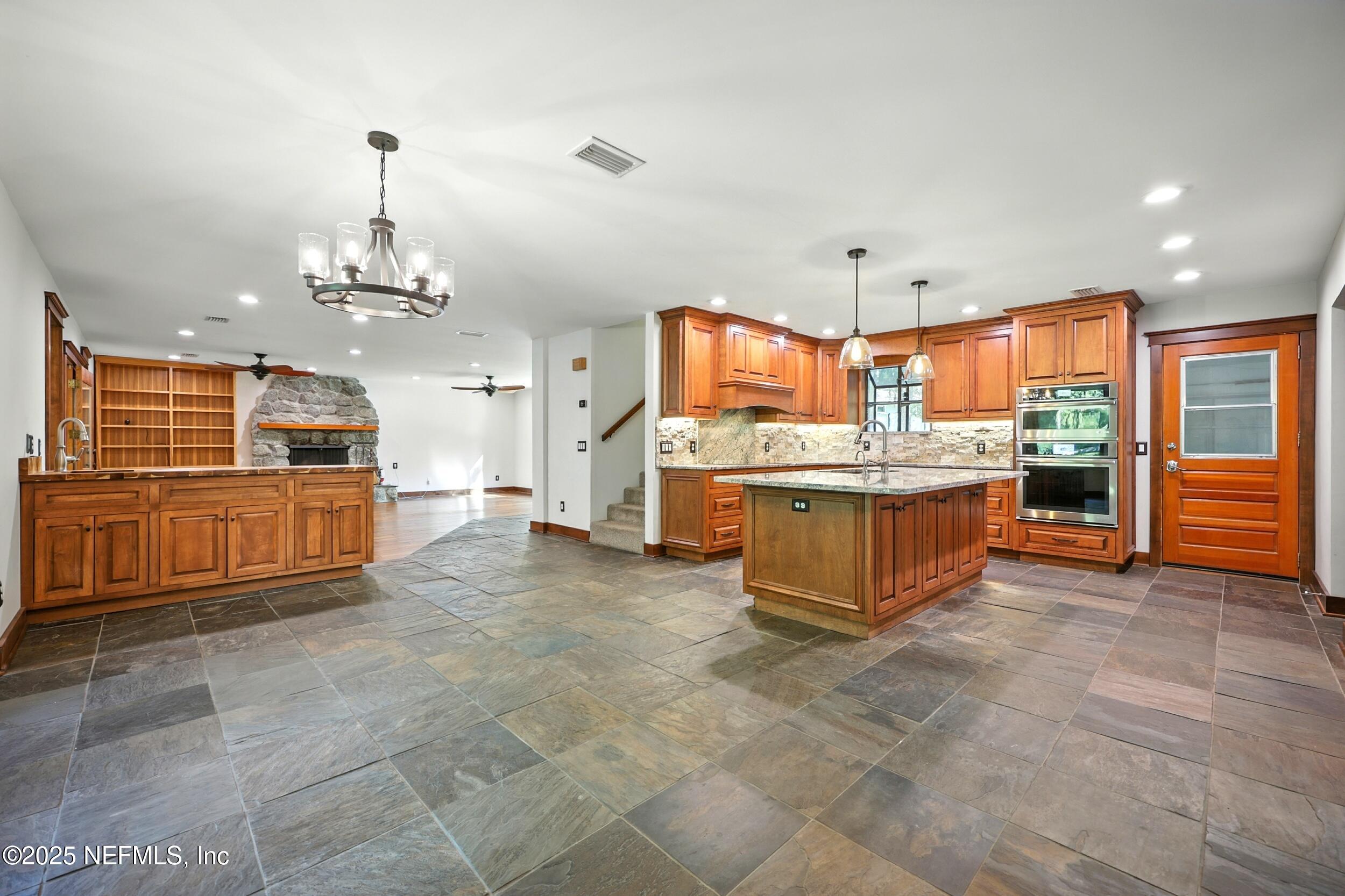 12534 Flynn Road Jacksonville, FL 32223 - Photo 11 of 90 a large kitchen with kitchen island a stove a sink a counter space and cabinets