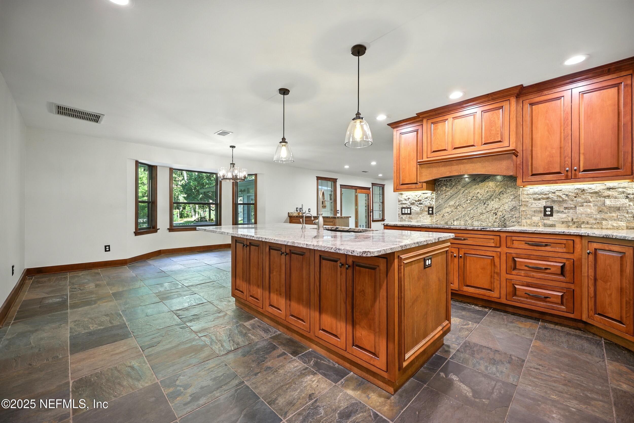 12534 Flynn Road Jacksonville, FL 32223 - Photo 12 of 90 a kitchen with kitchen island granite countertop a stove a sink and dishwasher wooden cabinets with granite countertop