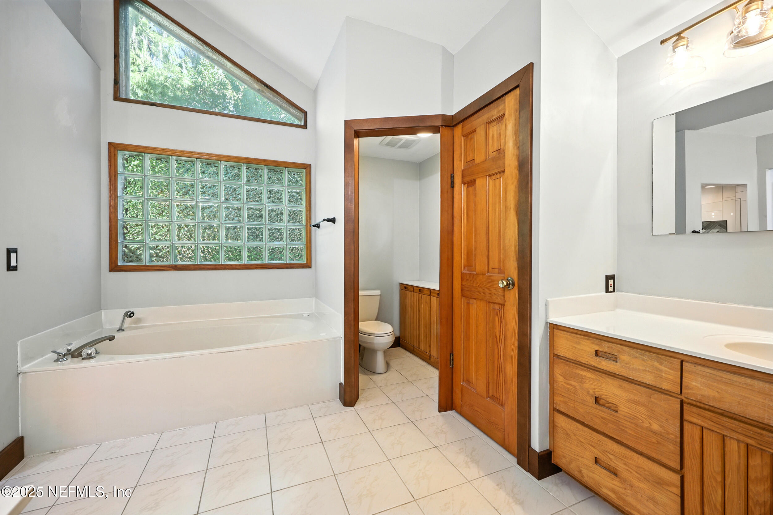 12534 Flynn Road Jacksonville, FL 32223 - Photo 25 of 90 a spacious bathroom with a tub sink and mirror