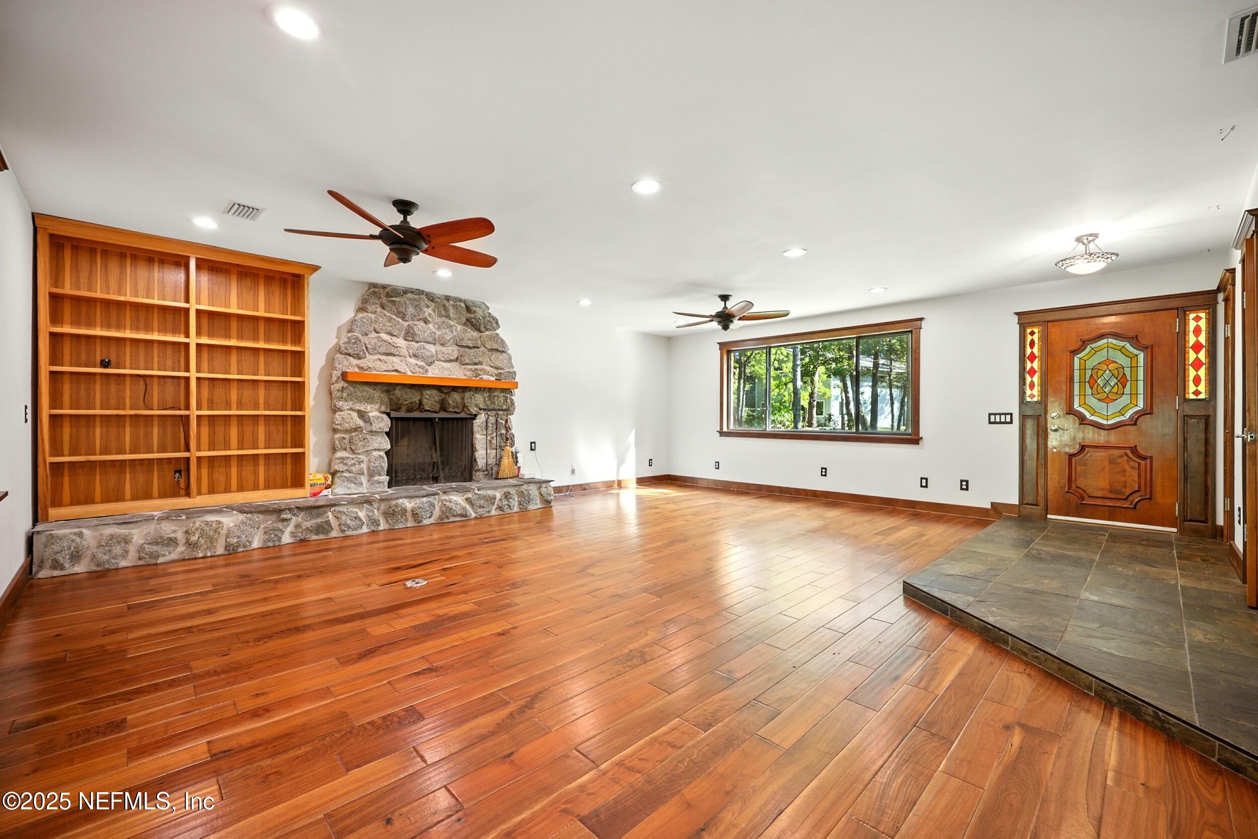 12534 Flynn Road Jacksonville, FL 32223 - Photo 9 of 90 an empty room with windows wooden floor and fireplace