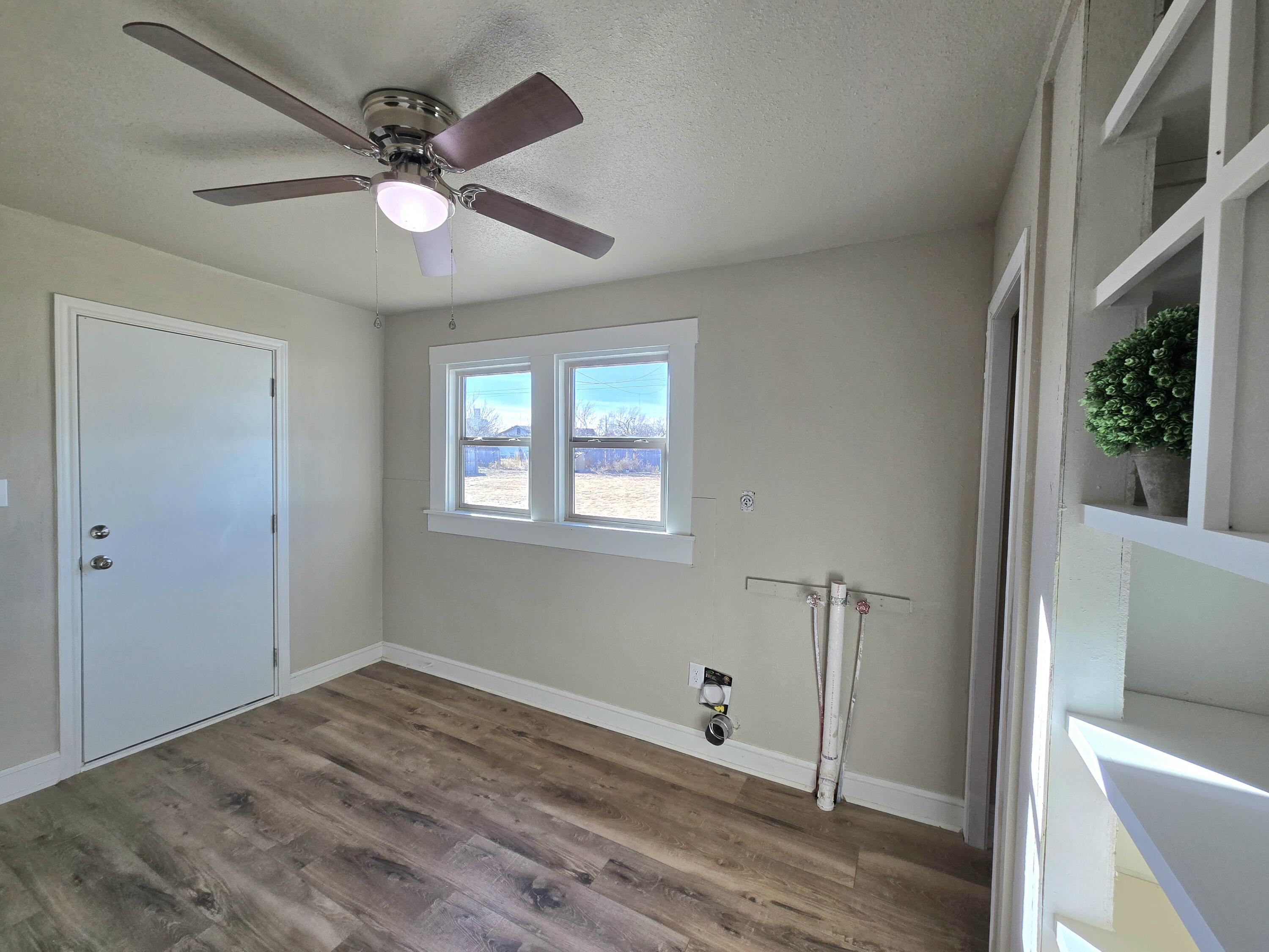 315 North Floyd Avenue Tulia, TX 79088 - Photo 11 of 24 a view of a livingroom with a ceiling fan and wooden floor