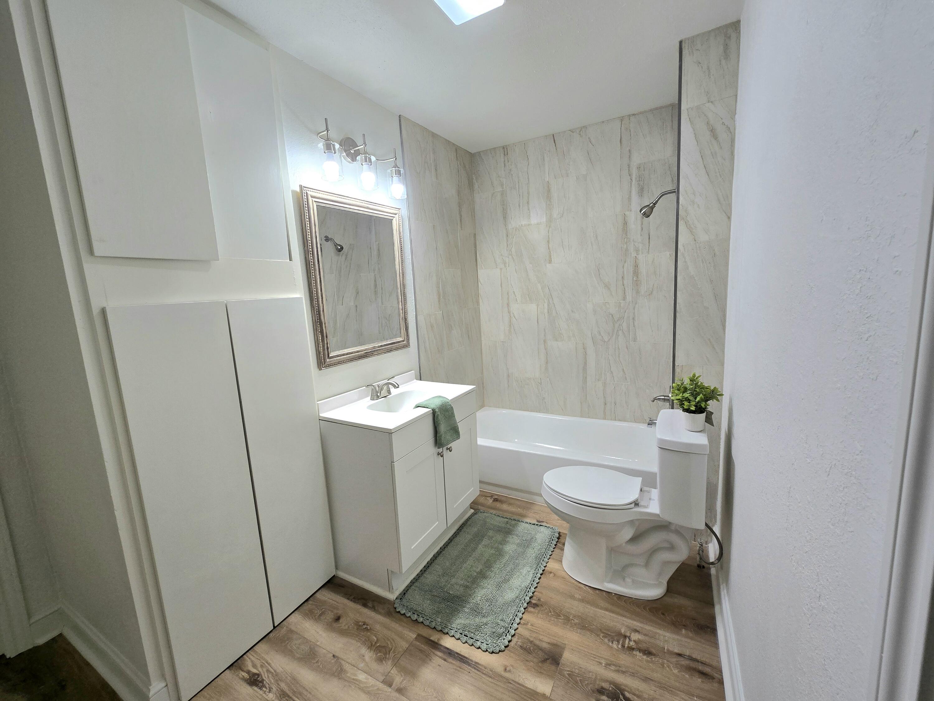 315 North Floyd Avenue Tulia, TX 79088 - Photo 14 of 24 a bathroom with a granite countertop sink toilet and shower