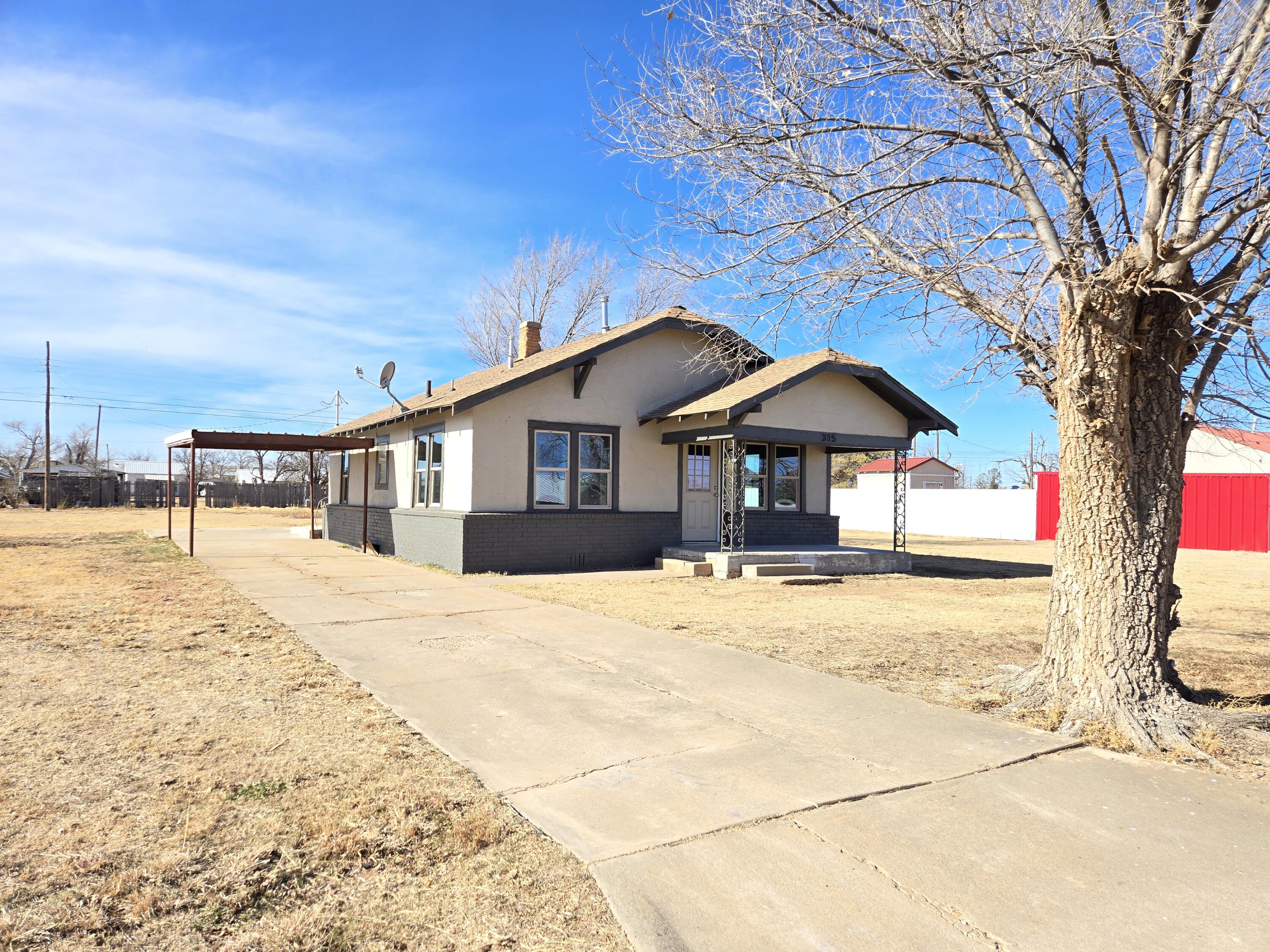315 North Floyd Avenue Tulia, TX 79088 - Photo 18 of 24 a front view of a house with a yard and garage