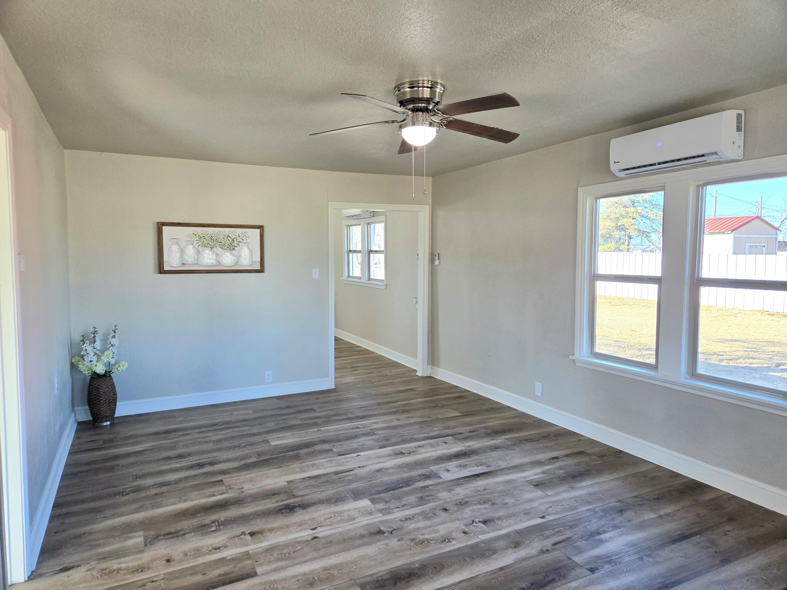 315 North Floyd Avenue Tulia, TX 79088 - Photo 3 of 24 a view of an empty room with wooden floor and a window