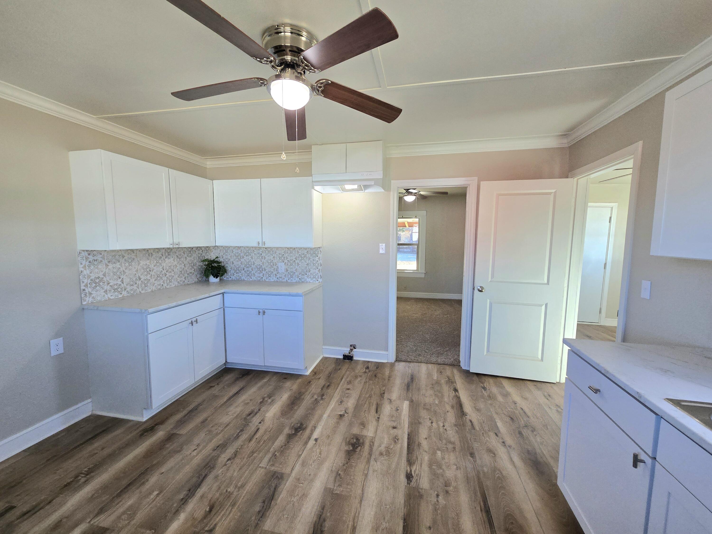 315 North Floyd Avenue Tulia, TX 79088 - Photo 10 of 24 a kitchen with granite countertop a stove cabinets and wooden floor