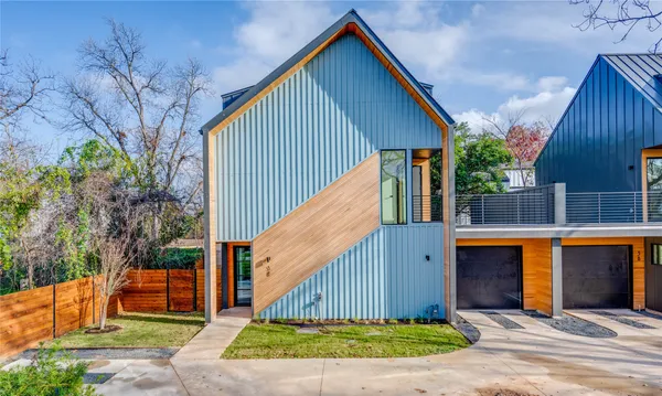 a view of backyard of house with wooden fence