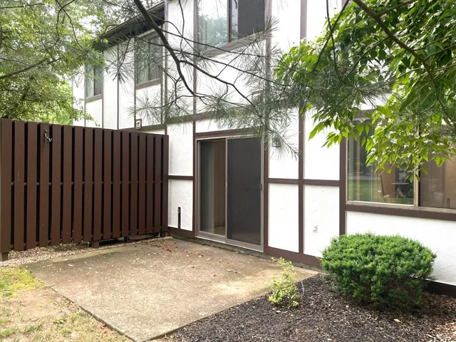 a view of a house with a backyard and a large tree