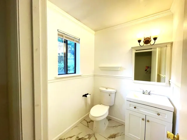 a bathroom with a toilet sink and mirror