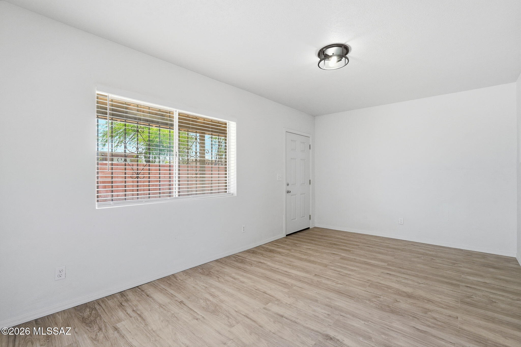 136 West Elvira Road Tucson, AZ 85756 - Photo 9 of 27 a view of an empty room with wooden floor and a window