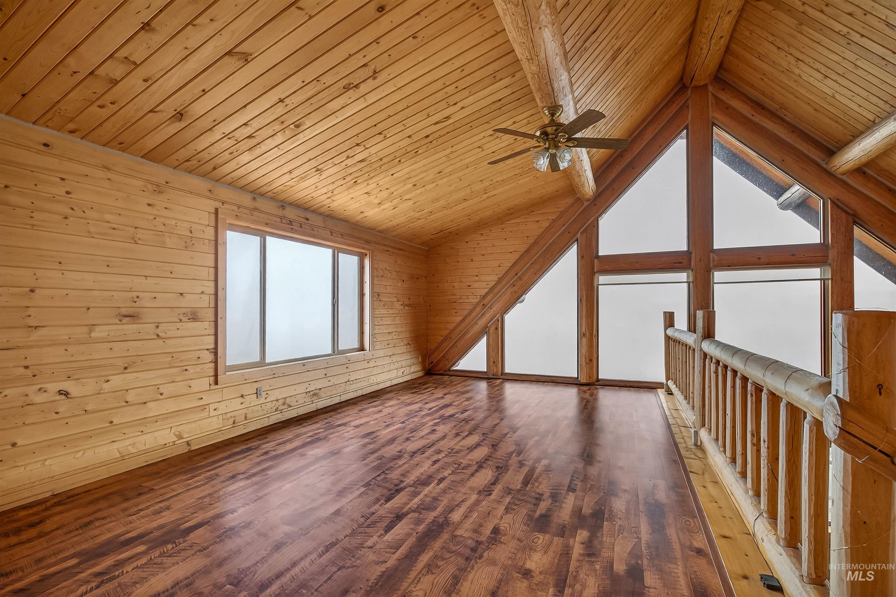 915 Doumecq Road White Bird, ID 83554 - Photo 31 of 49 Additional living space featuring wood finished floors, a ceiling fan, a wooden ceiling with exposed beams, and wooden walls