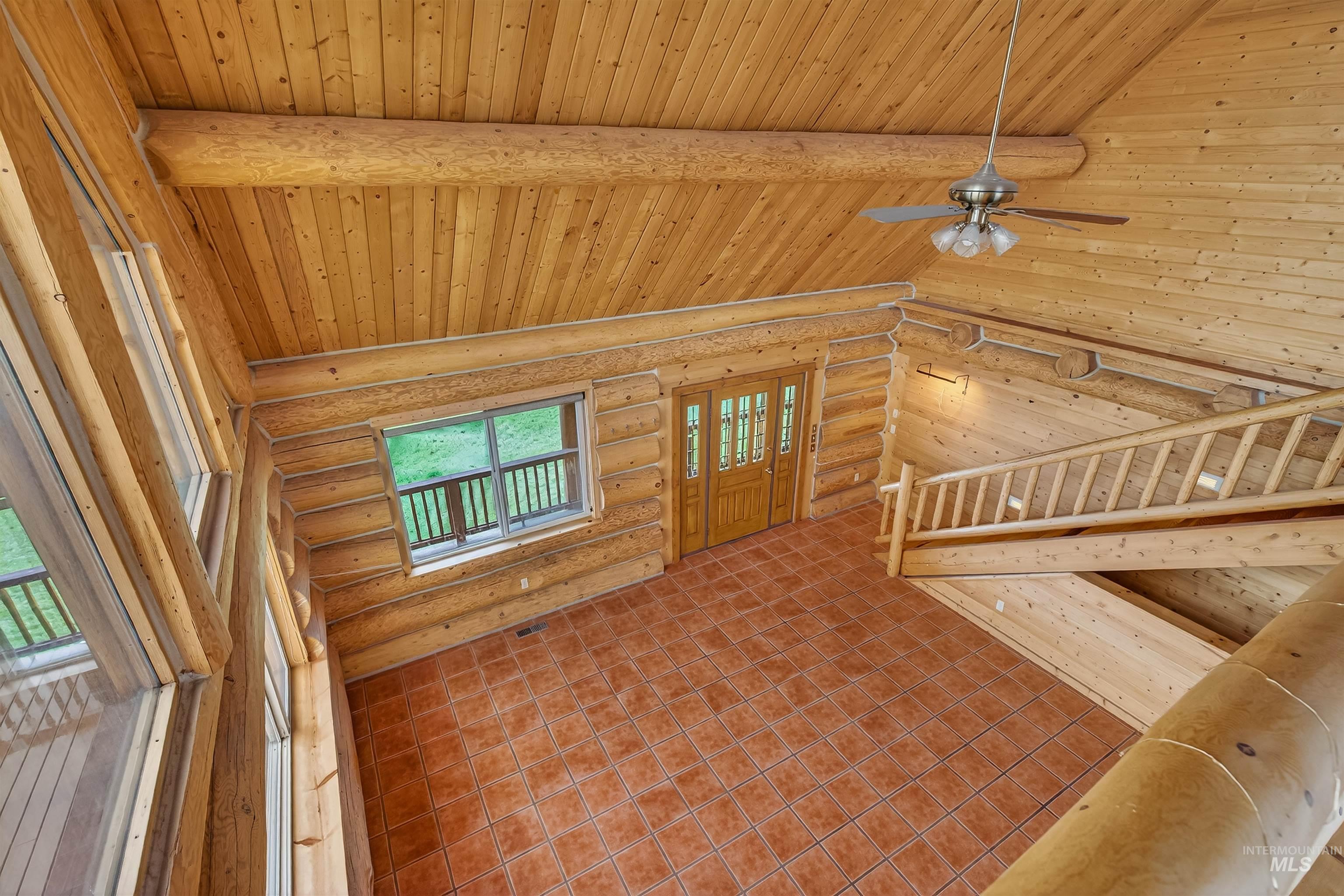 915 Doumecq Road White Bird, ID 83554 - Photo 33 of 49 Unfurnished living room with log walls, a high wood beamed ceiling, and a ceiling fan