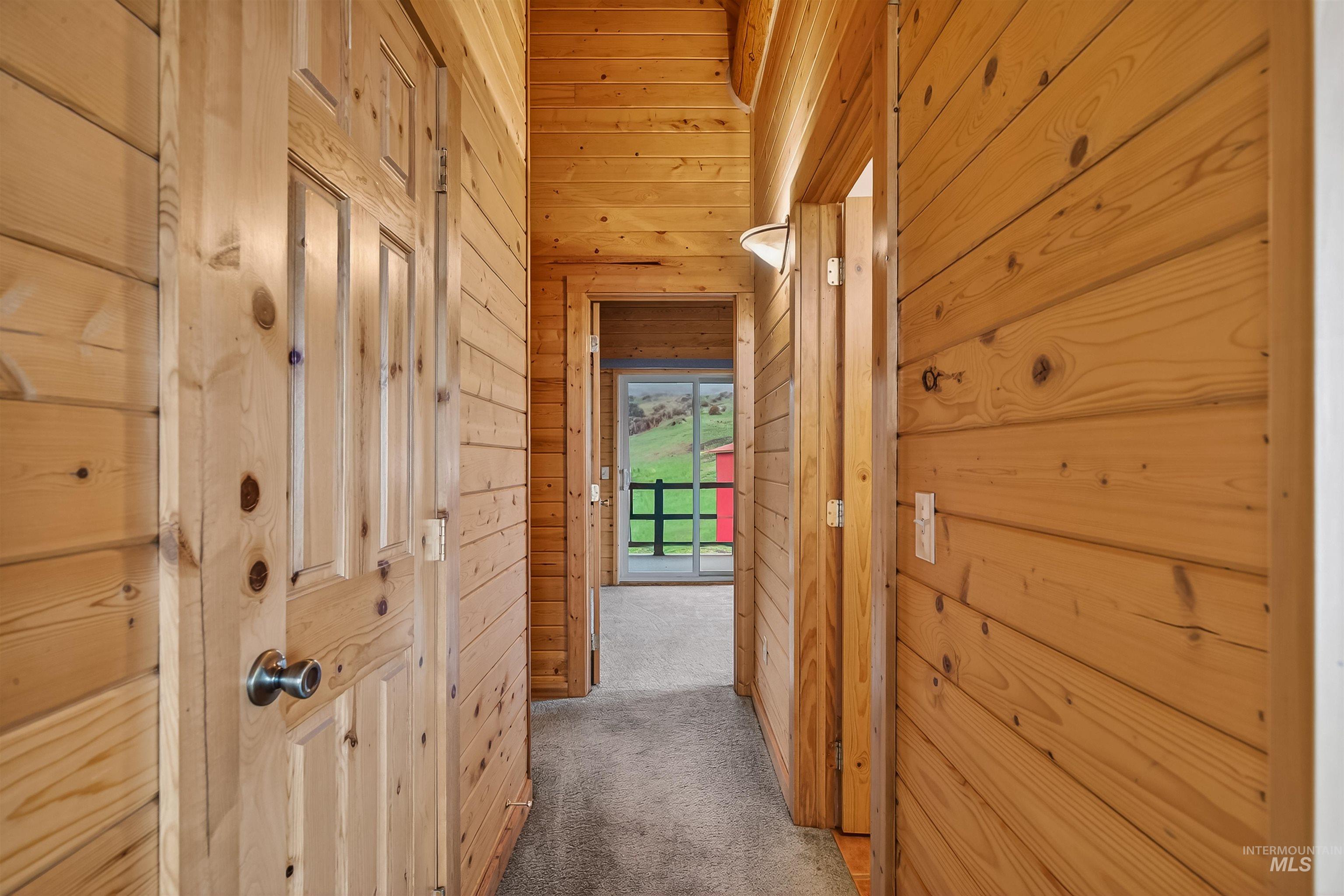 915 Doumecq Road White Bird, ID 83554 - Photo 34 of 49 Hallway with wood walls and carpet flooring