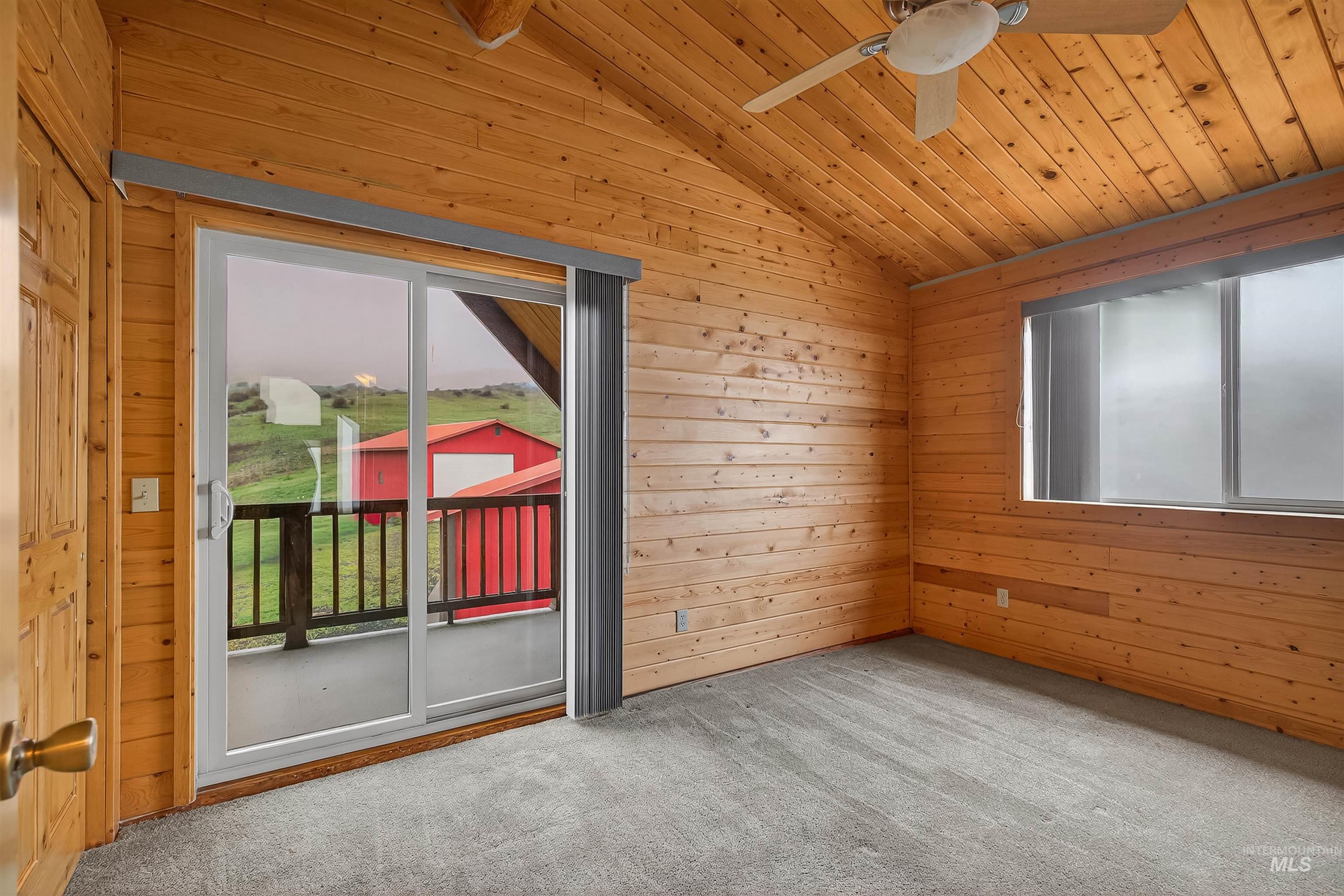 915 Doumecq Road White Bird, ID 83554 - Photo 36 of 49 Carpeted empty room with wood walls, ceiling fan, and a vaulted wood ceiling
