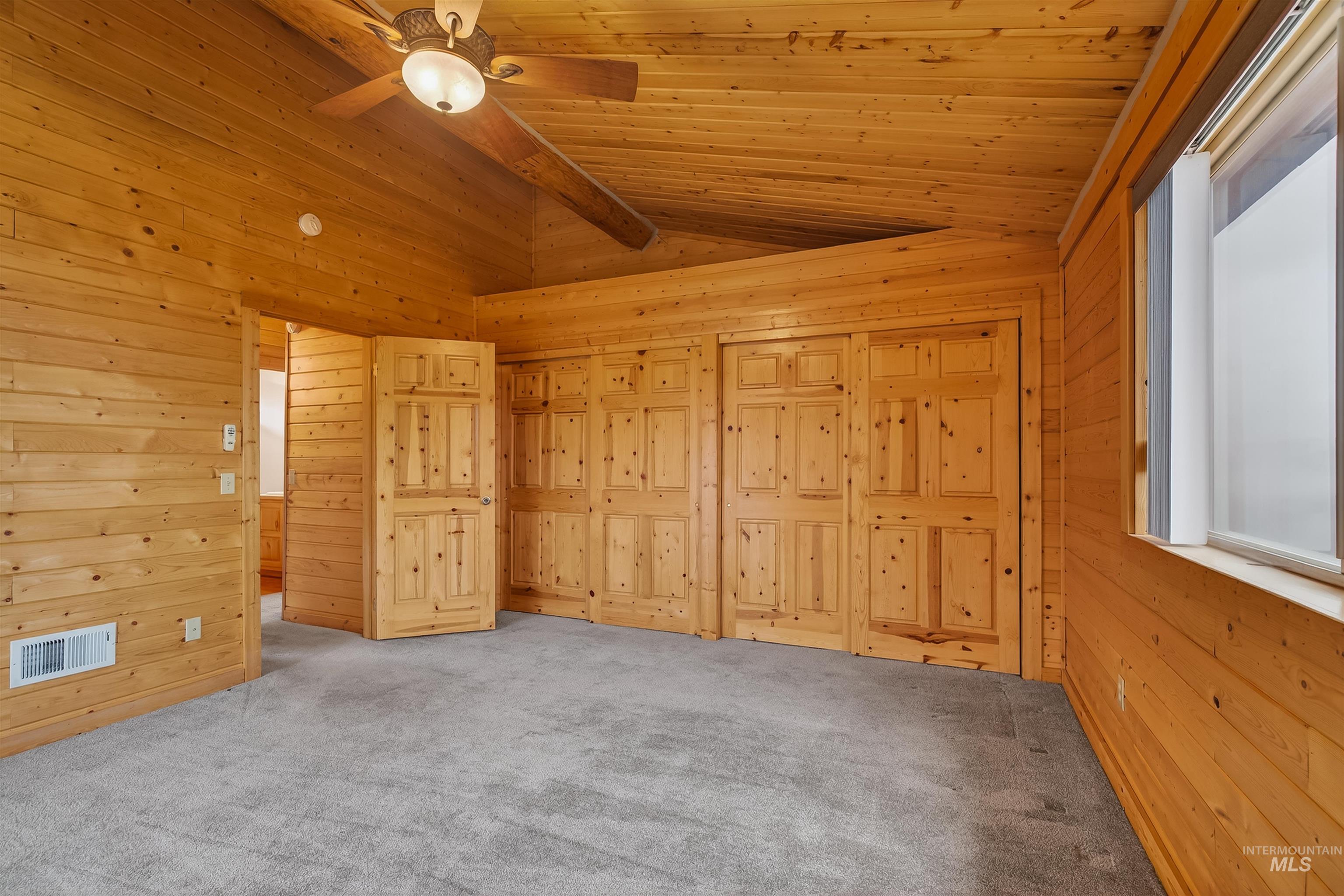 915 Doumecq Road White Bird, ID 83554 - Photo 39 of 49 Unfurnished bedroom with carpet floors, lofted ceiling, a ceiling fan, and wooden walls