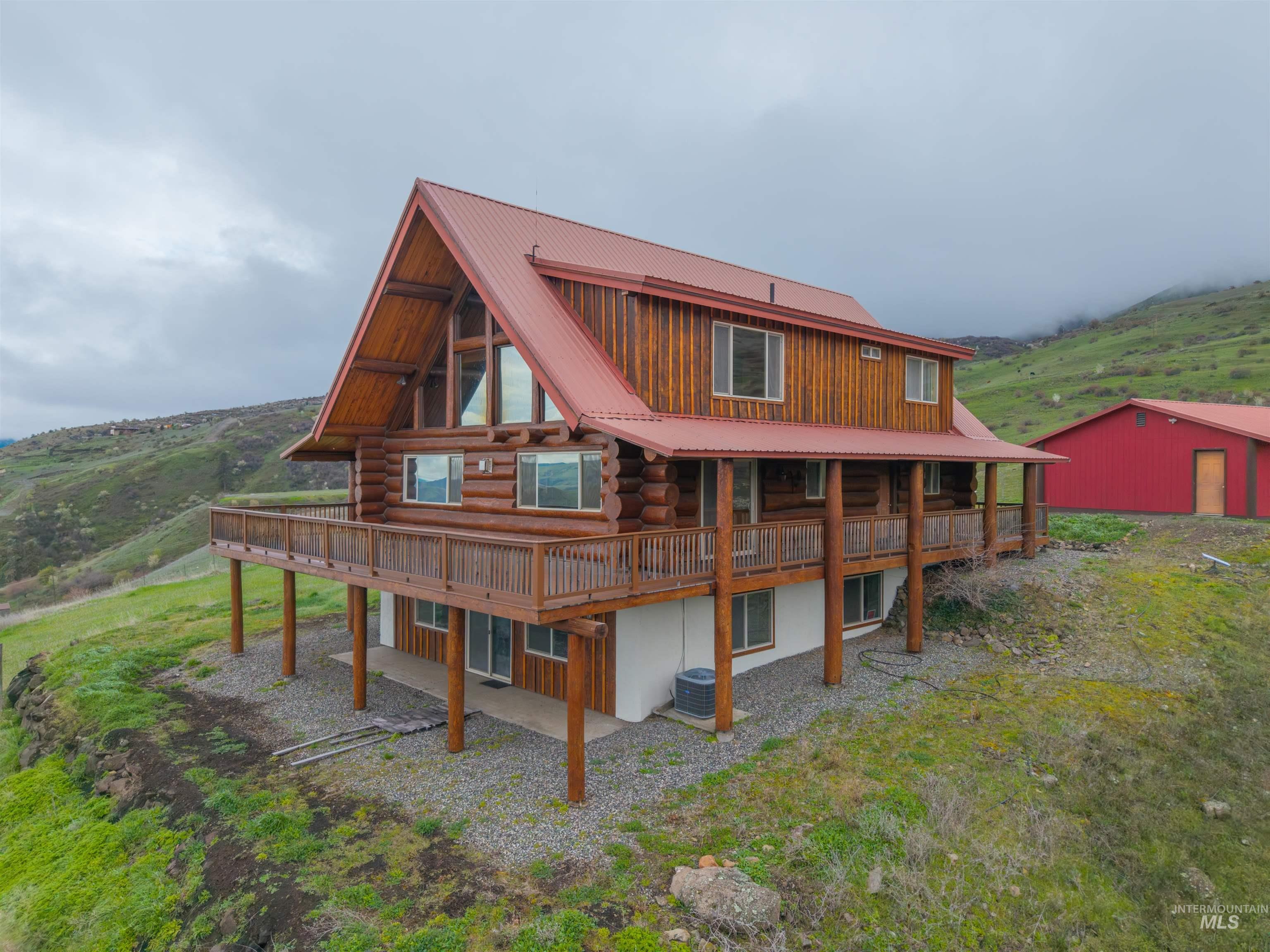 915 Doumecq Road White Bird, ID 83554 - Photo 5 of 49 Back of property with log siding, a metal roof, and a wooden deck