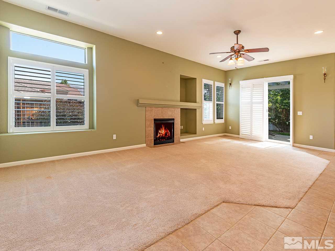 1790 Oxcart Court Reno, NV 89521 - Photo 7 of 20 a view of an empty room with chandelier fan and fireplace
