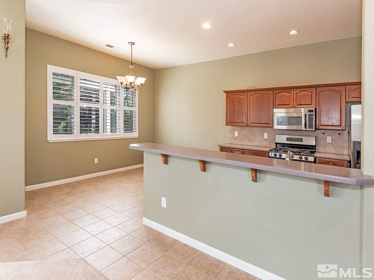 1790 Oxcart Court Reno, NV 89521 - Photo 10 of 20 a kitchen with stainless steel appliances granite countertop a stove a sink and a microwave