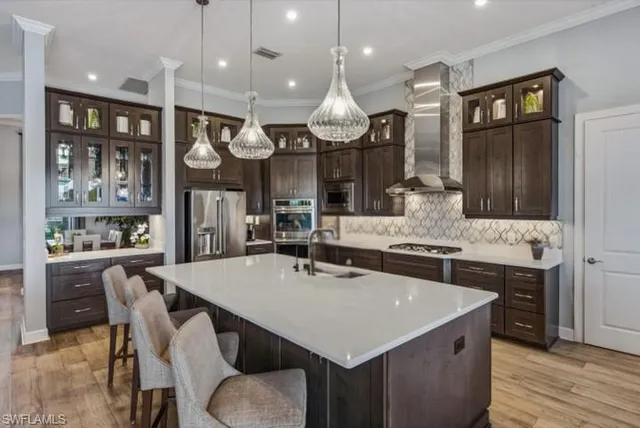 a kitchen with stainless steel appliances granite countertop a sink a stove and a refrigerator