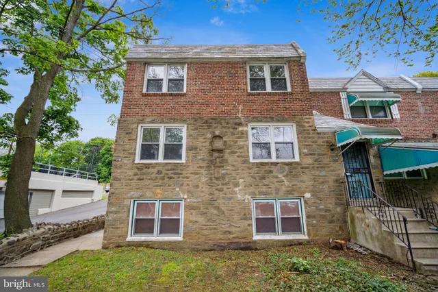 front view of a brick house with a small yard