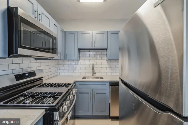 a kitchen with granite countertop cabinets stove top oven and sink