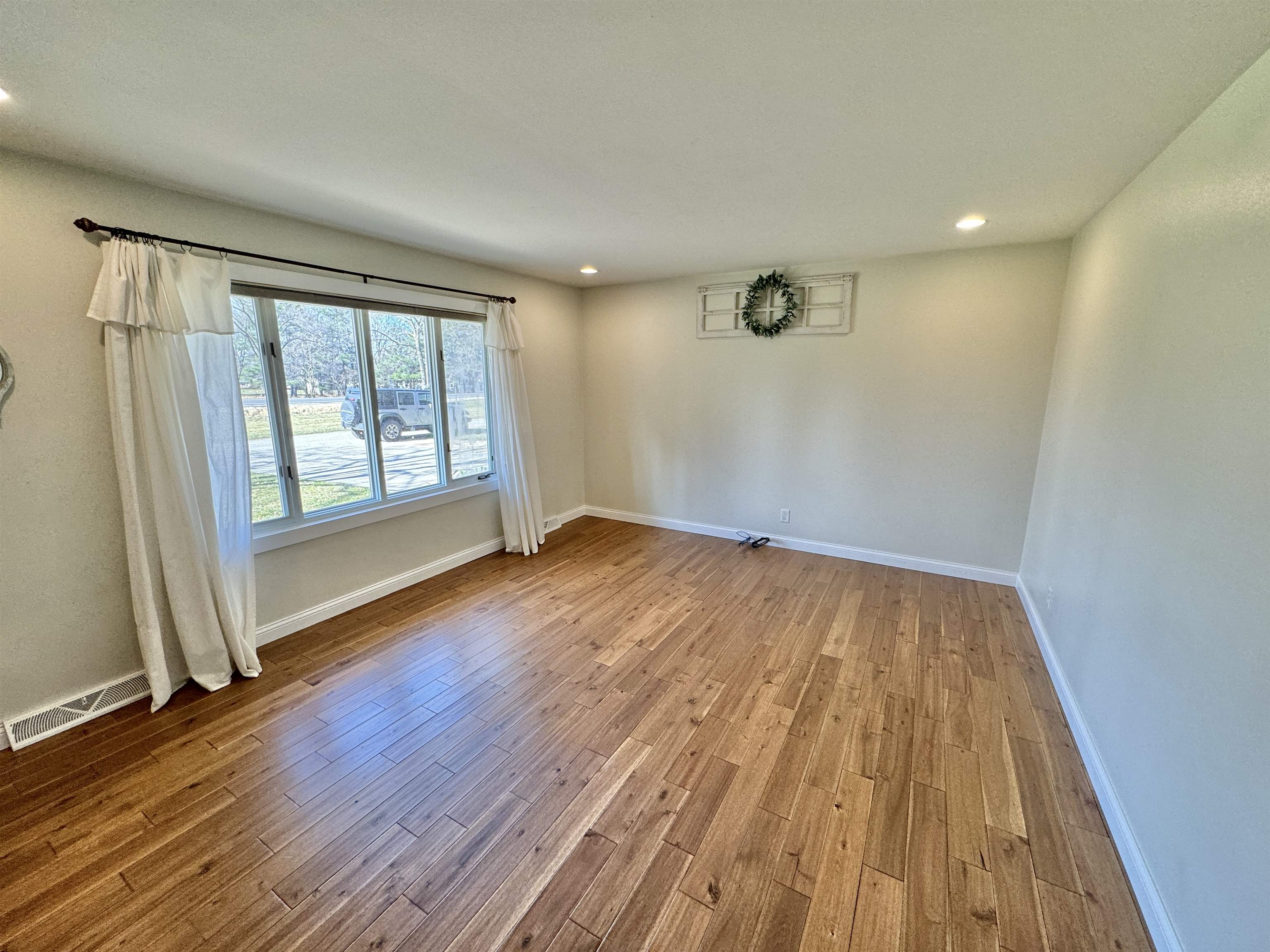 6694 Belvidere Road Roscoe, IL 61073 - Photo 12 of 32 an empty room with wooden floor and windows