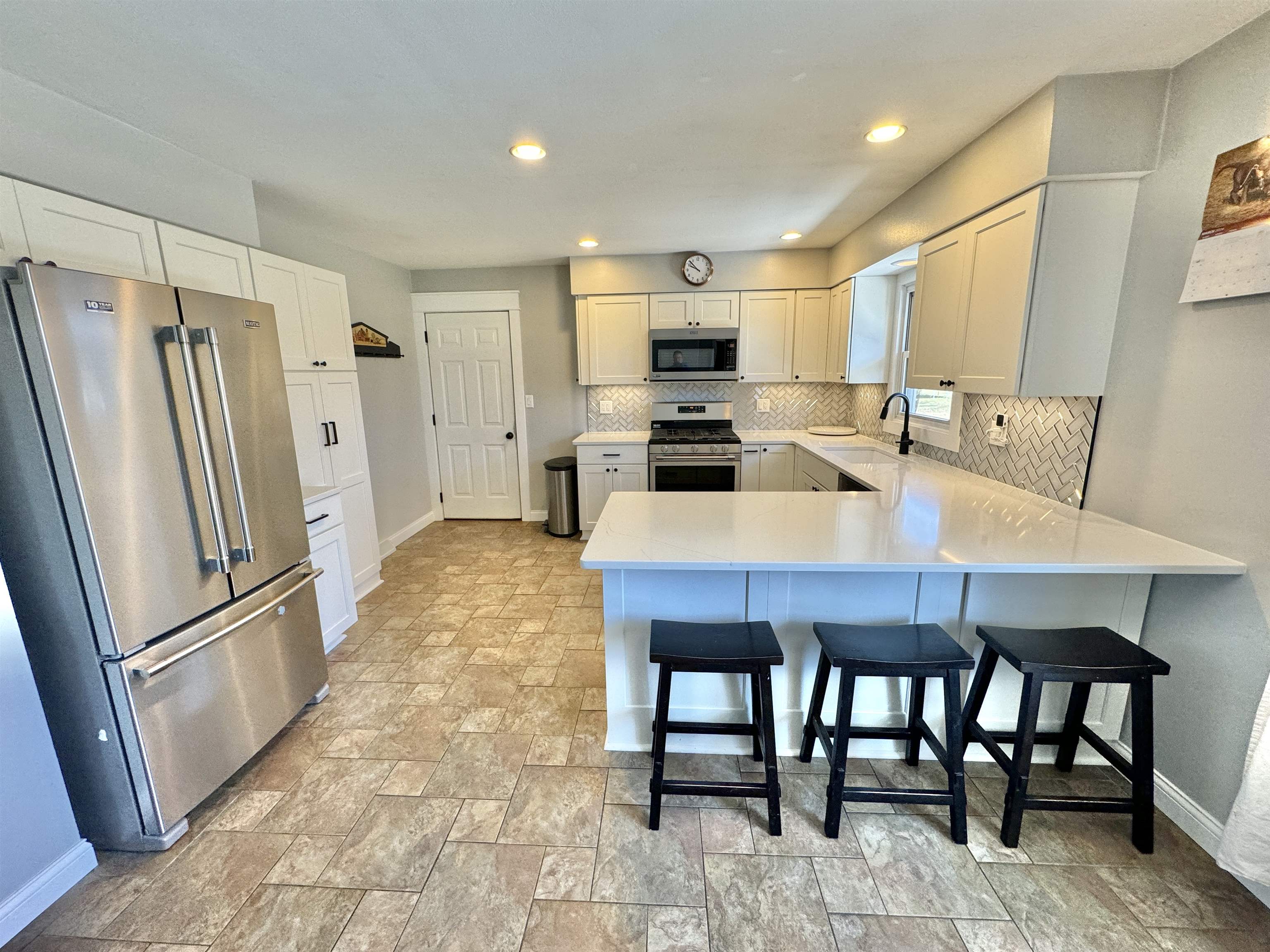6694 Belvidere Road Roscoe, IL 61073 - Photo 16 of 32 a kitchen with stainless steel appliances a table chairs and refrigerator