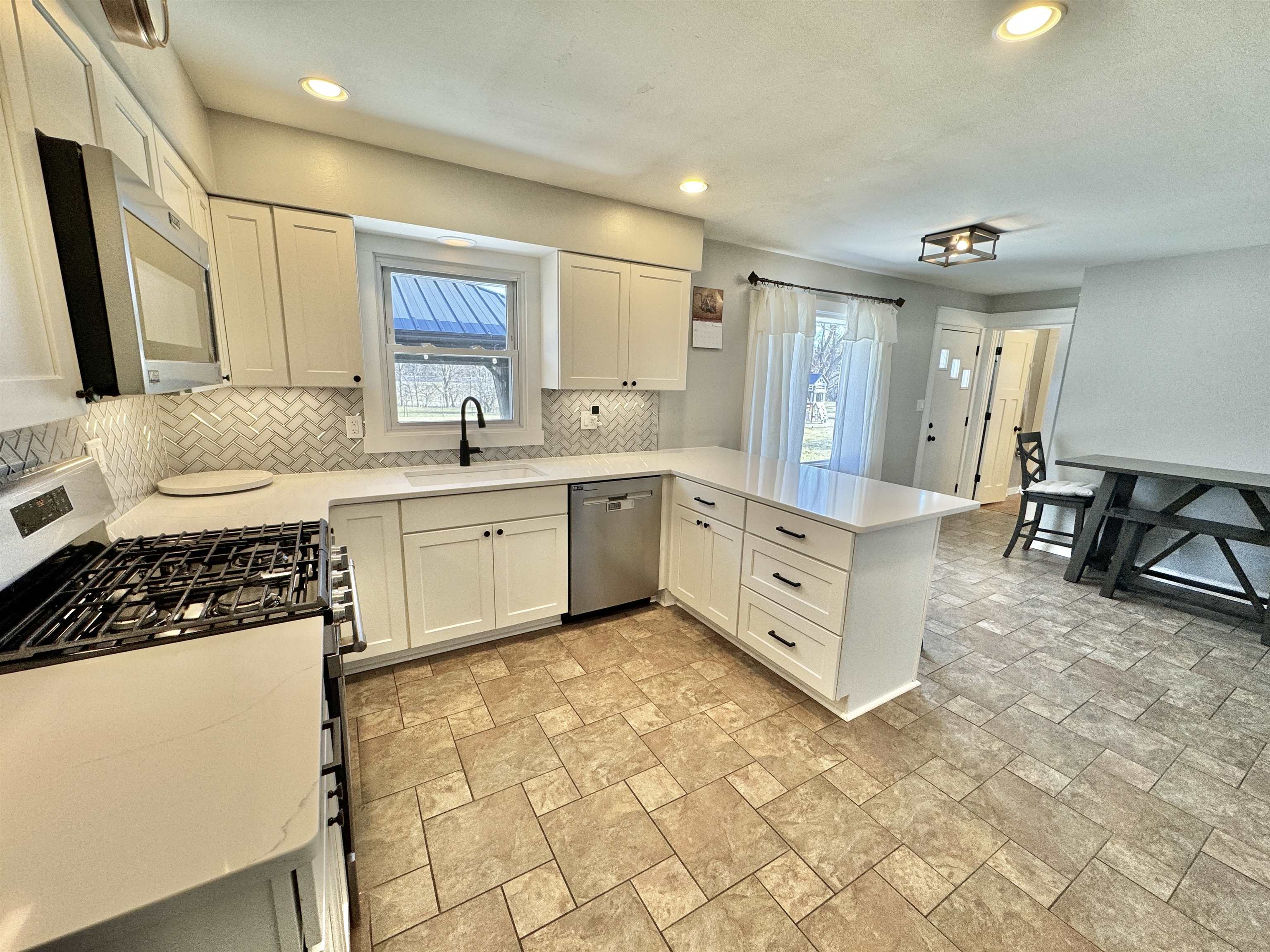 6694 Belvidere Road Roscoe, IL 61073 - Photo 23 of 32 a large white kitchen with cabinets