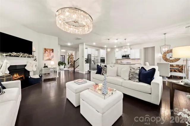 a living room with furniture a flat screen tv and kitchen view
