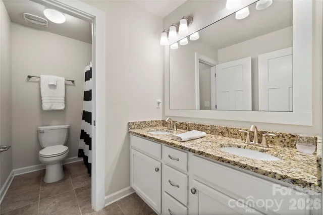 a spacious bedroom with a bed and a lamp