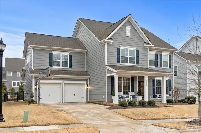 a view of a house with a yard and large tree