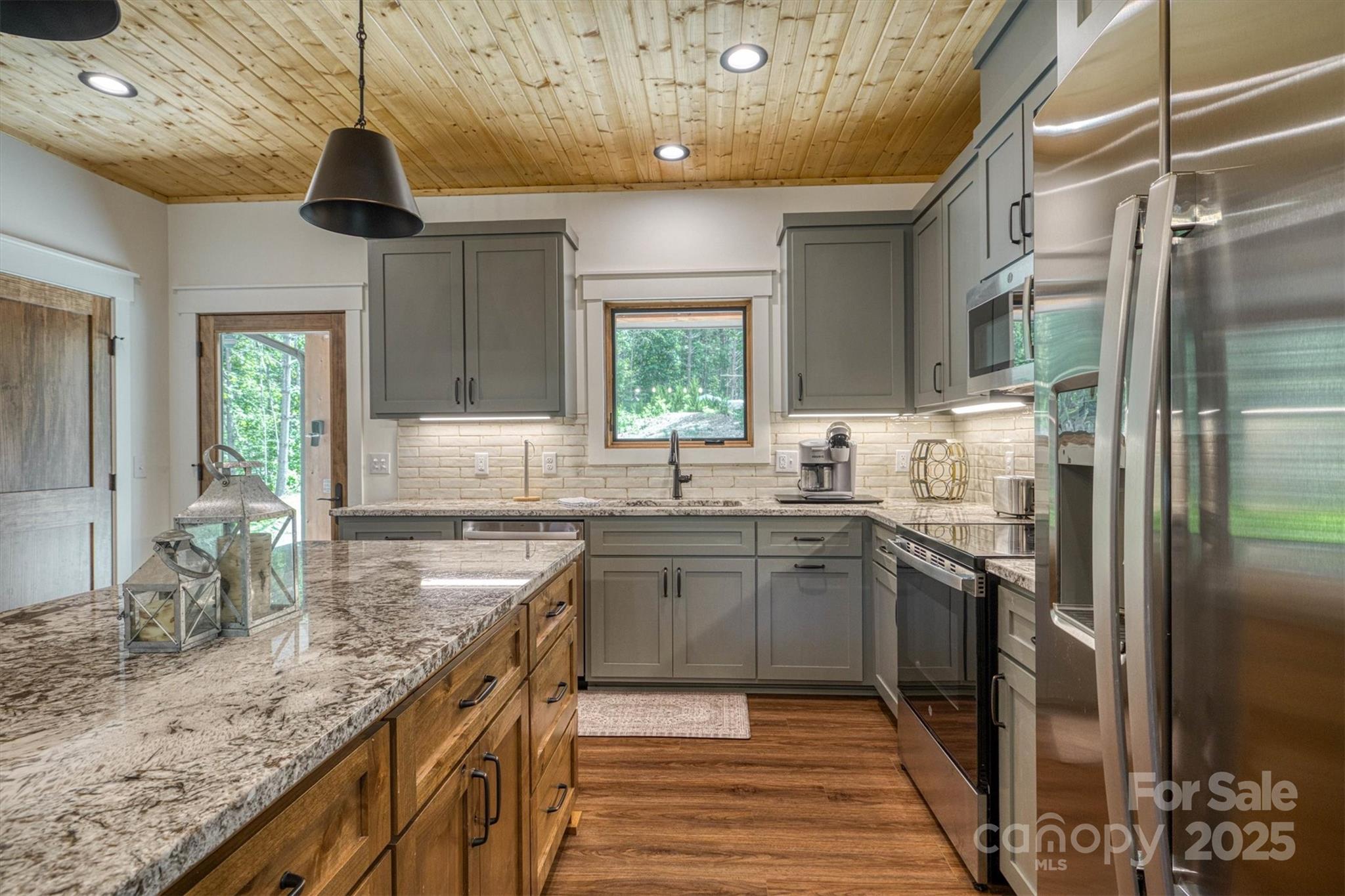 1370 Saylor Way, Unit 8 Nebo, NC 28761 - Photo 19 of 44 a kitchen with stainless steel appliances granite countertop a sink a stove and a refrigerator