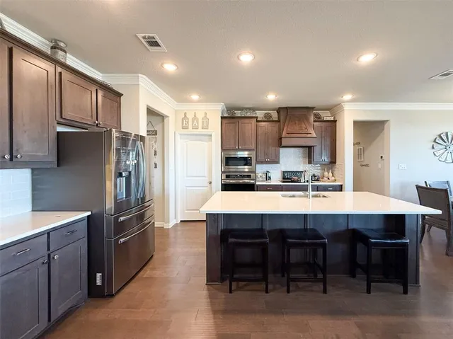 a large kitchen with kitchen island a sink stainless steel appliances and cabinets