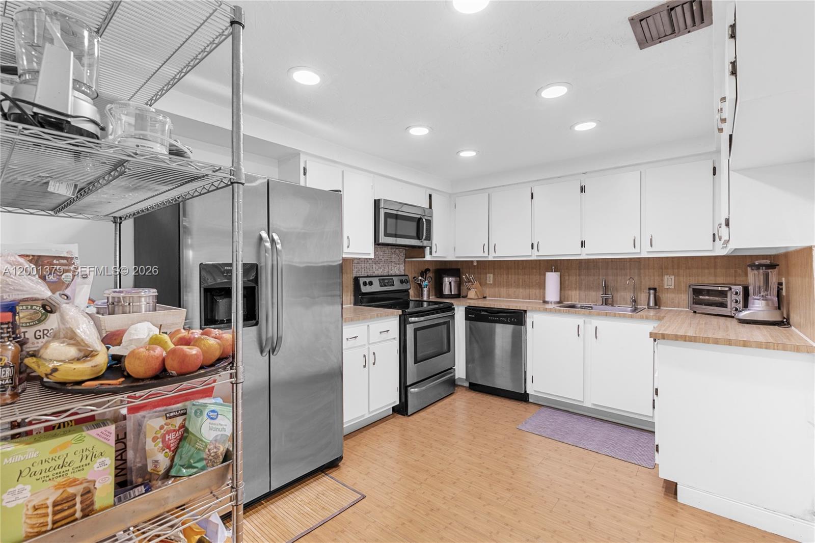 16251 Golf Club Road, Unit 311 Weston, FL 33326 - Photo 12 of 38 a kitchen with stainless steel appliances granite countertop a refrigerator and a stove top oven