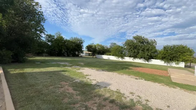 a view of a field with trees in the background