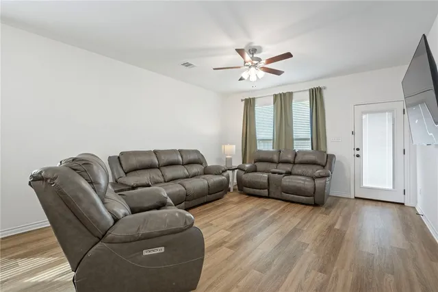 a living room with furniture and a wooden floor