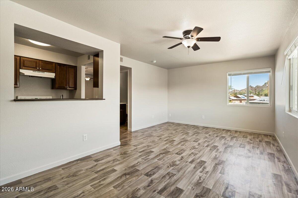 1346 East Mountain View Road, Unit 209 Phoenix, AZ 85020 - Photo 14 of 31 a view of a livingroom with a ceiling fan and wooden floor