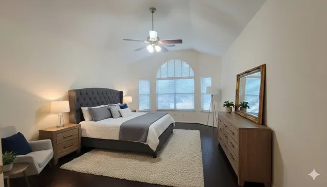 a bedroom with a bed couches and a large window